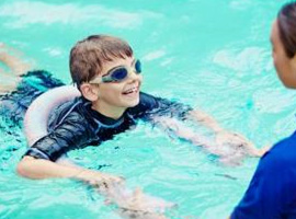 Child at swimming lessons smiling